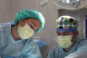 Two surgeons working on patient.