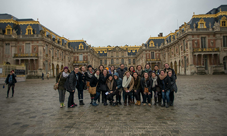 Study abroad group poses for a photo outside a palace