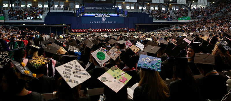 students with decorated commencement caps at graduation