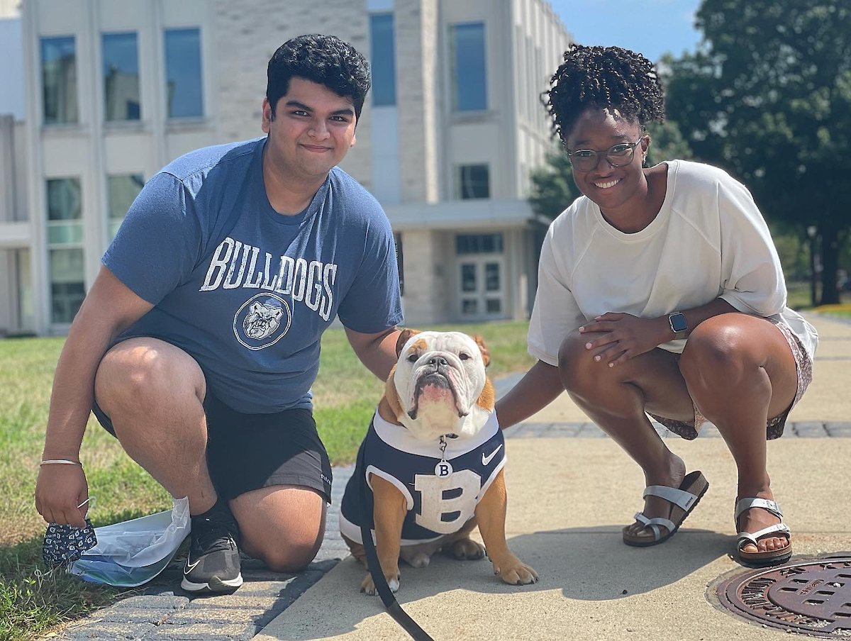 Two students kneel next to Blue, the Butler bulldog.