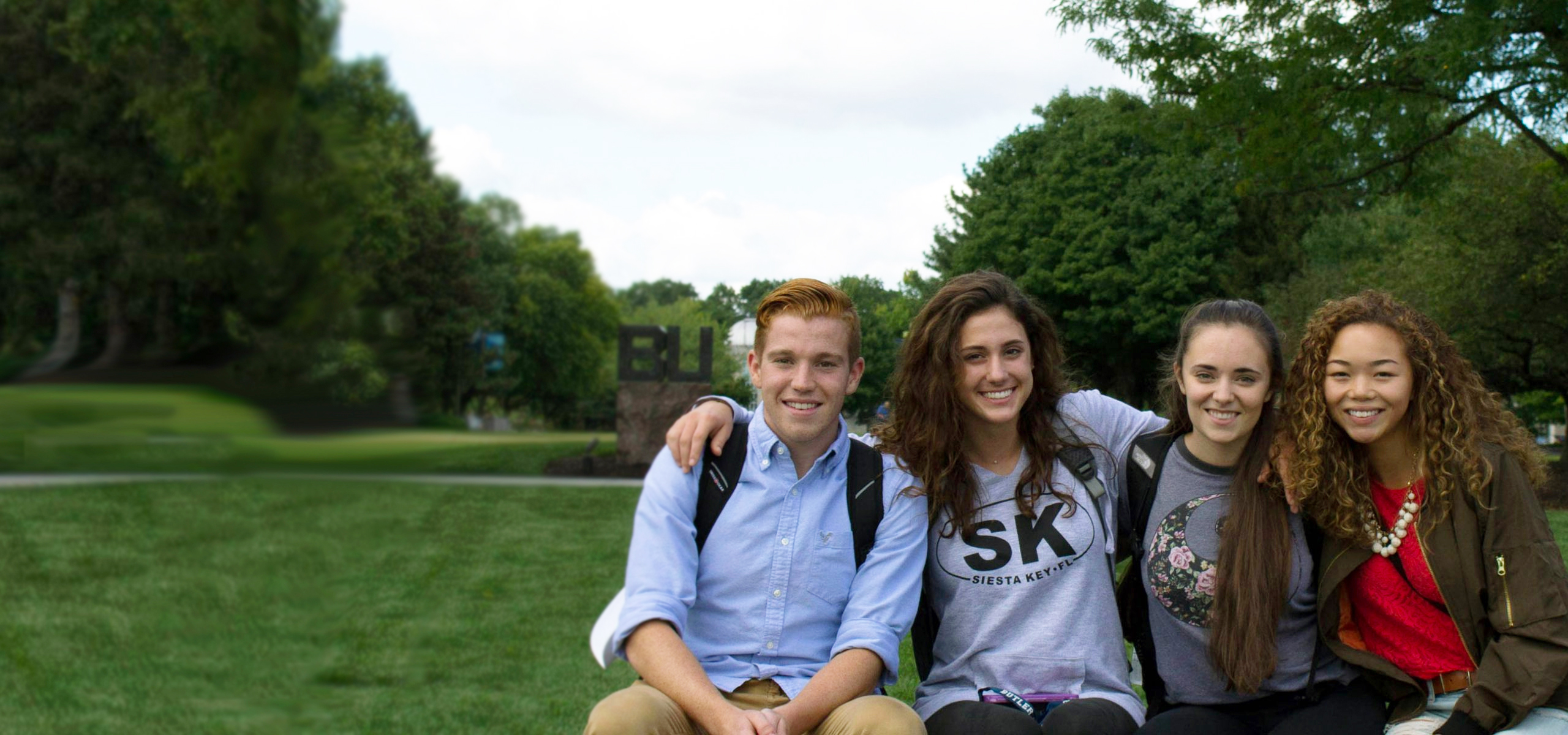 students sitting in front of the BU sign