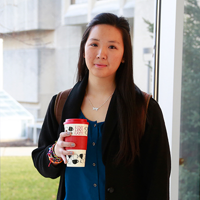 Eshan Pua holding a drink and looking at the camera