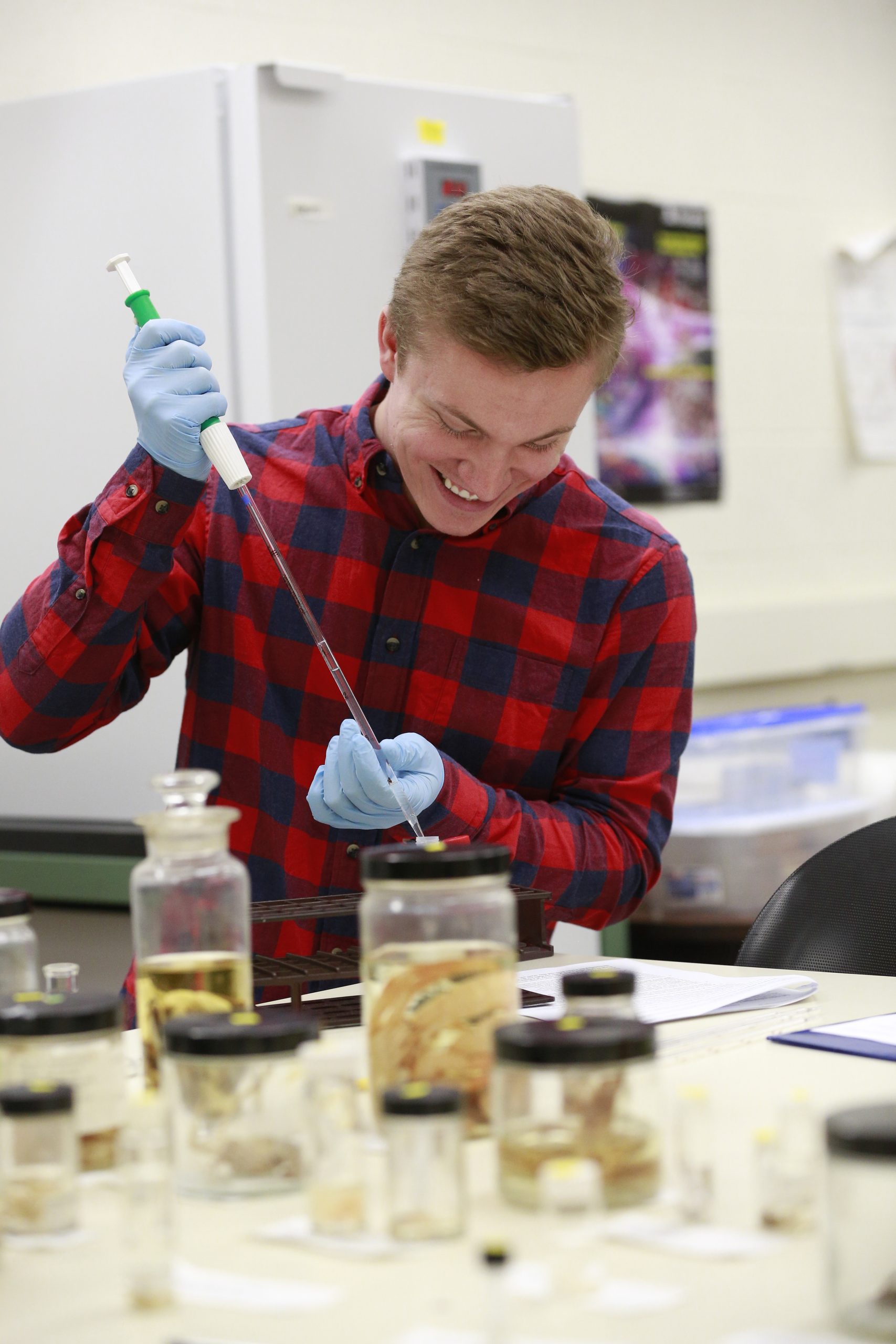 Male student in a science lab performing an experiment.