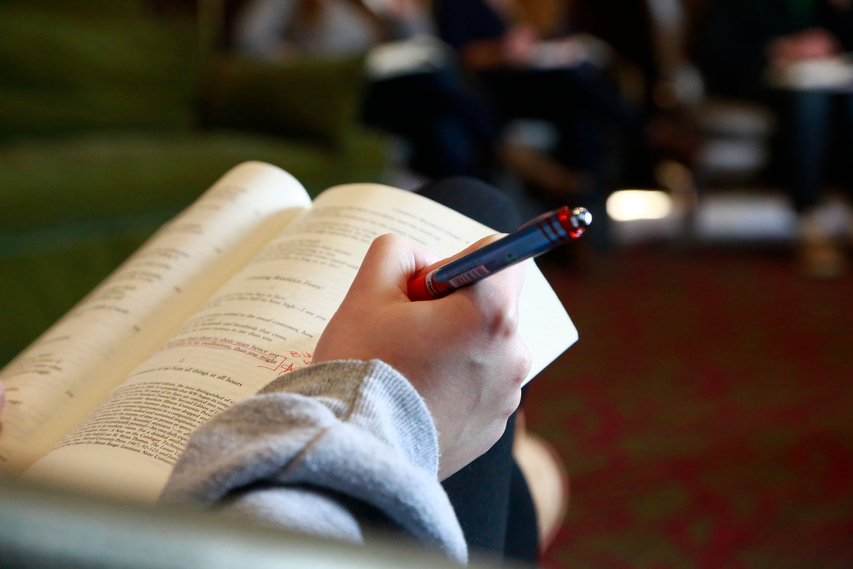 Student makes notations in book during English class