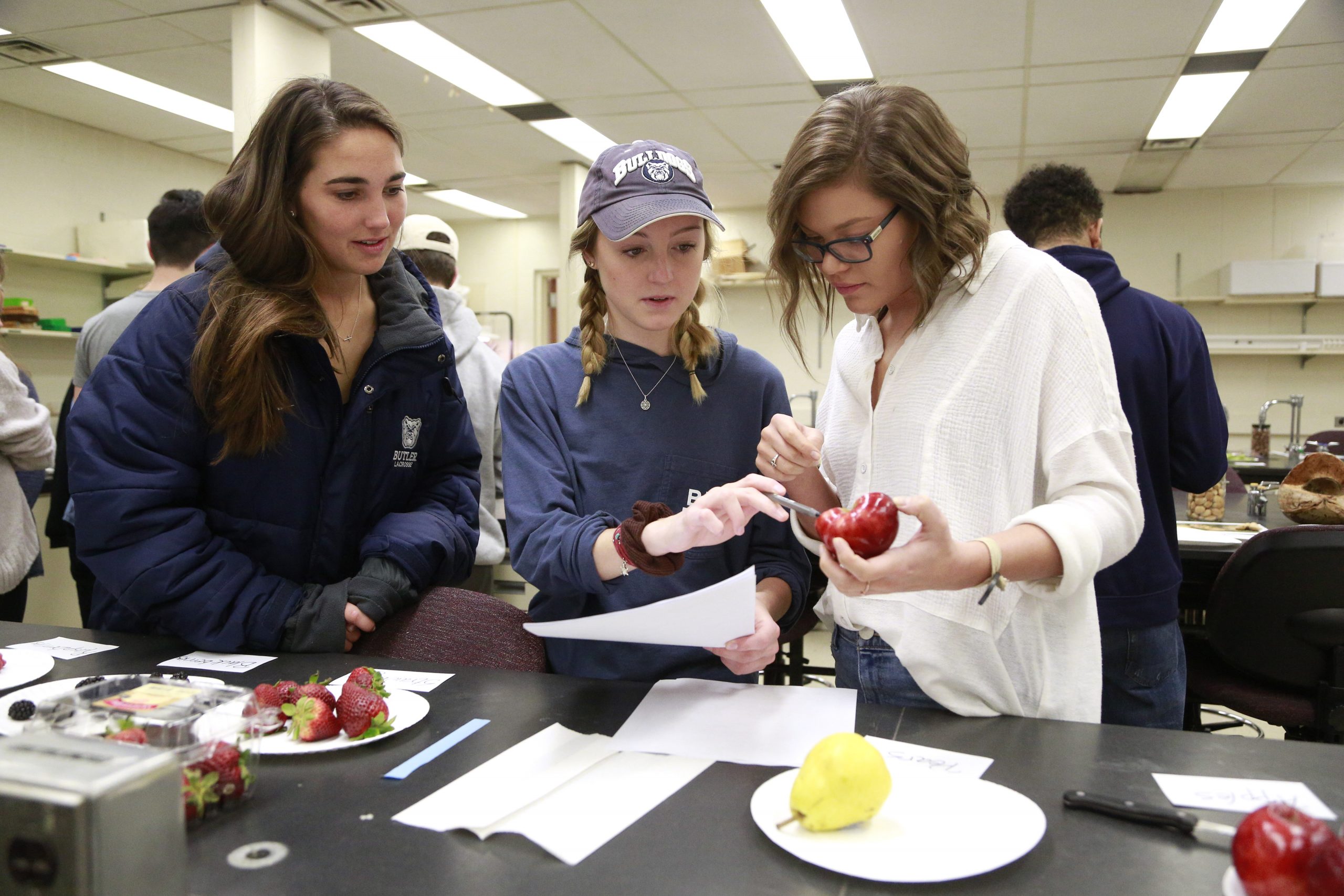 Three female students in a science laboratory performing an experiment.