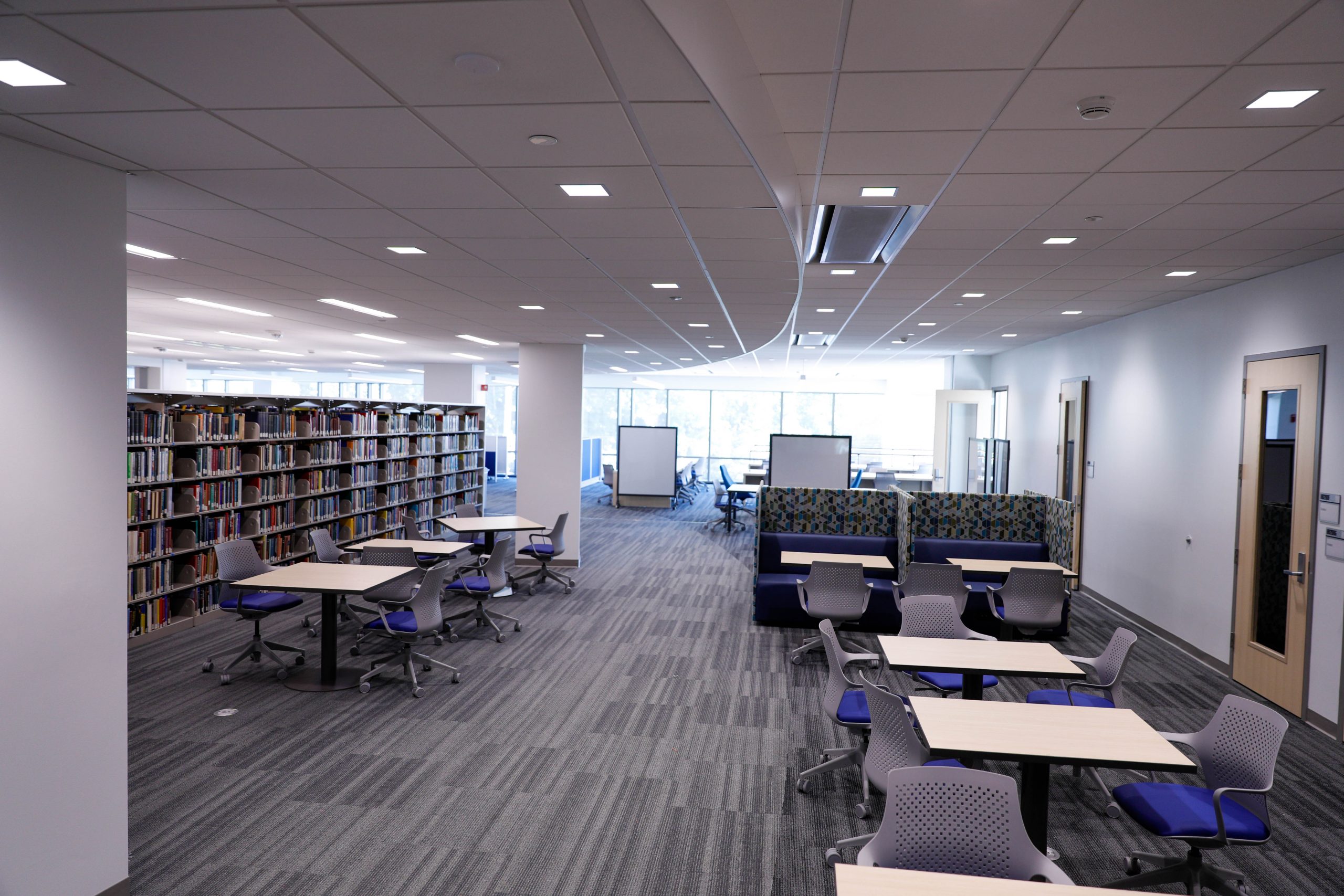 The science library in the new Sciences Complex, filled with small tables, some open for group work, others surrounded by dividers for individual studying