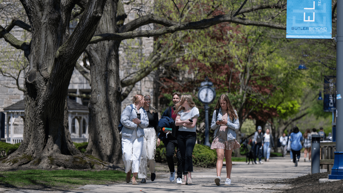 Students walk down a sidewalk on Butler's campus