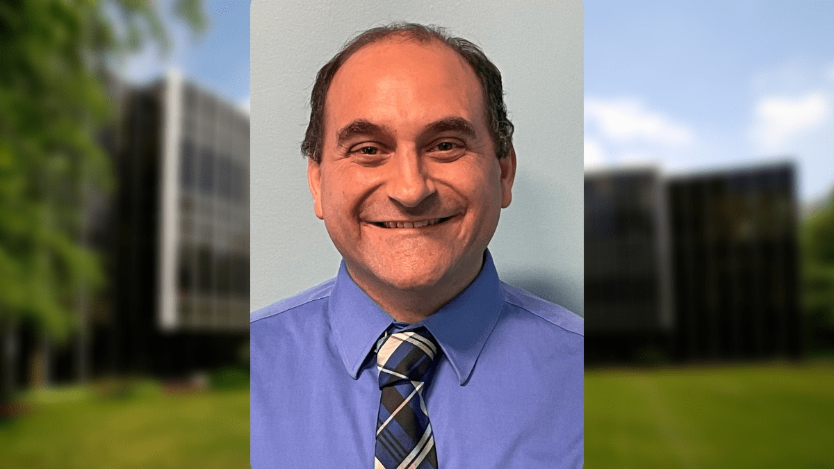 A man is smiling and wearing a tie