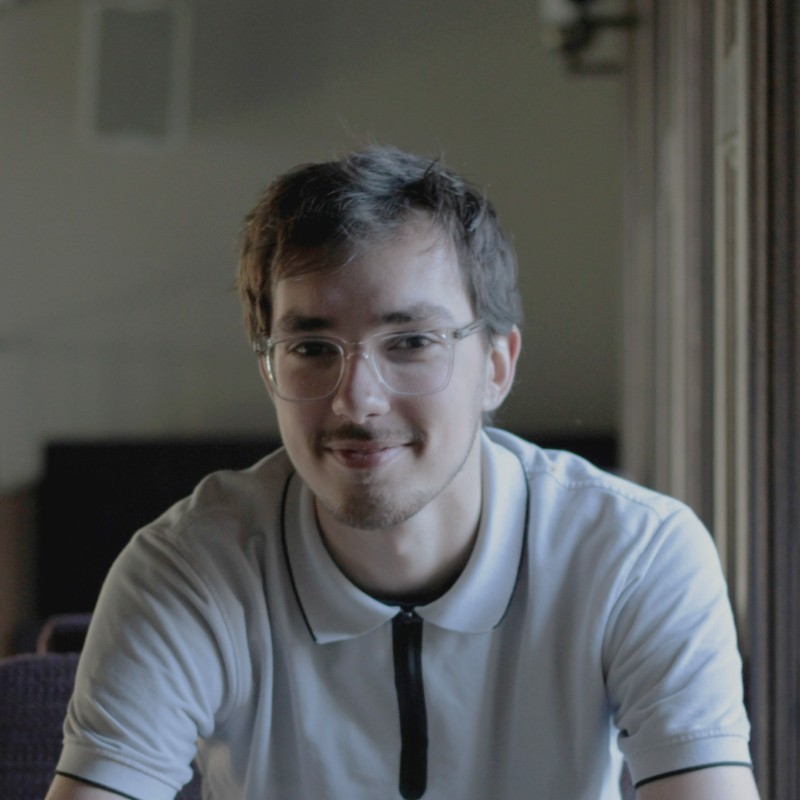 Man wearing glasses, sitting and smiling