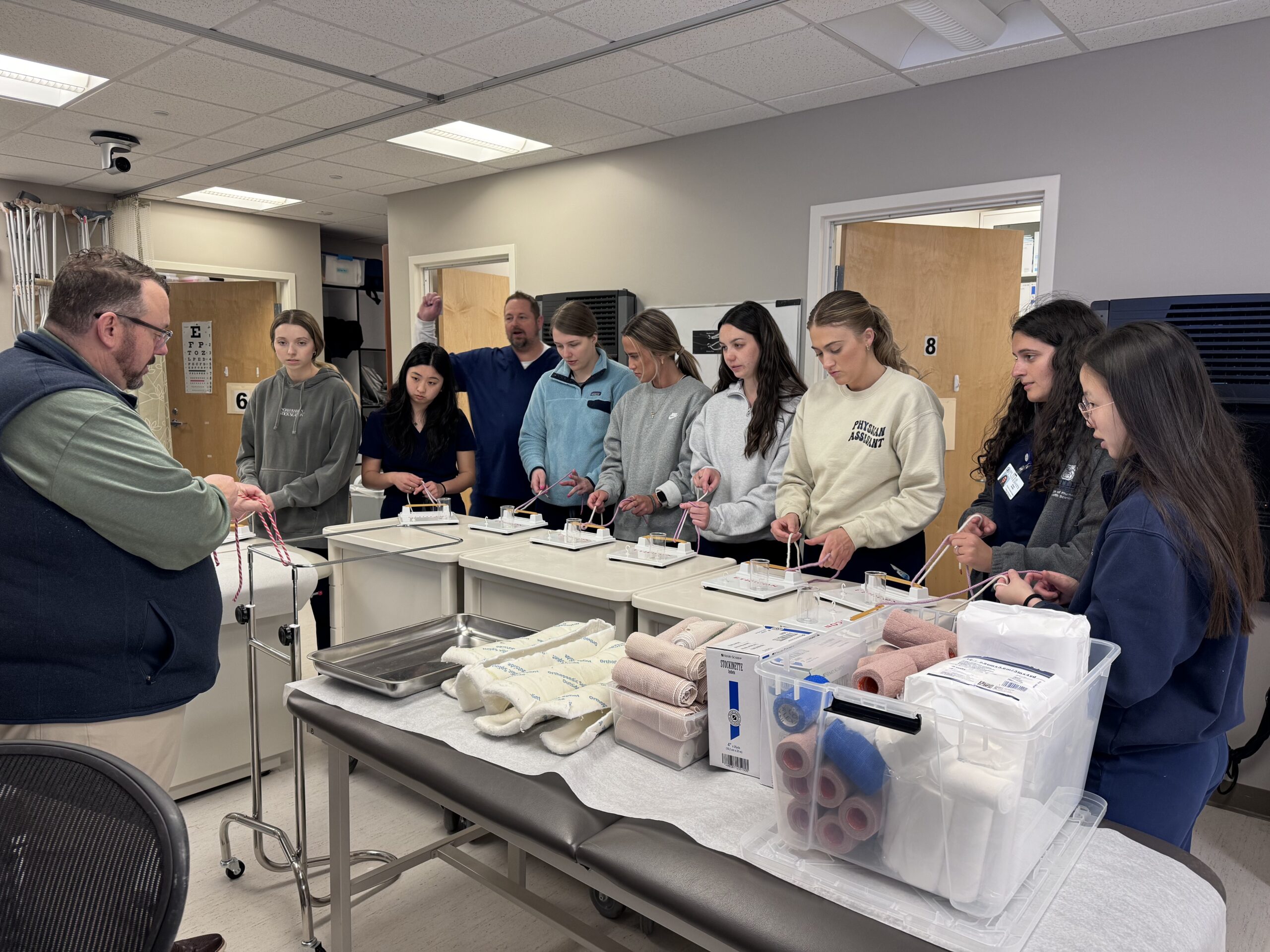 A group of PA students practicing intubation techniques with guidance from a faculty member