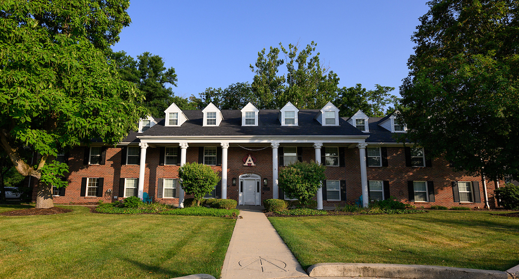 Alpha Phi house, red brick three story, white dormers, white pillars in front
