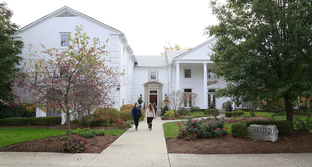 pi beta phi house, all white brick, pitched room, students entering on walkway