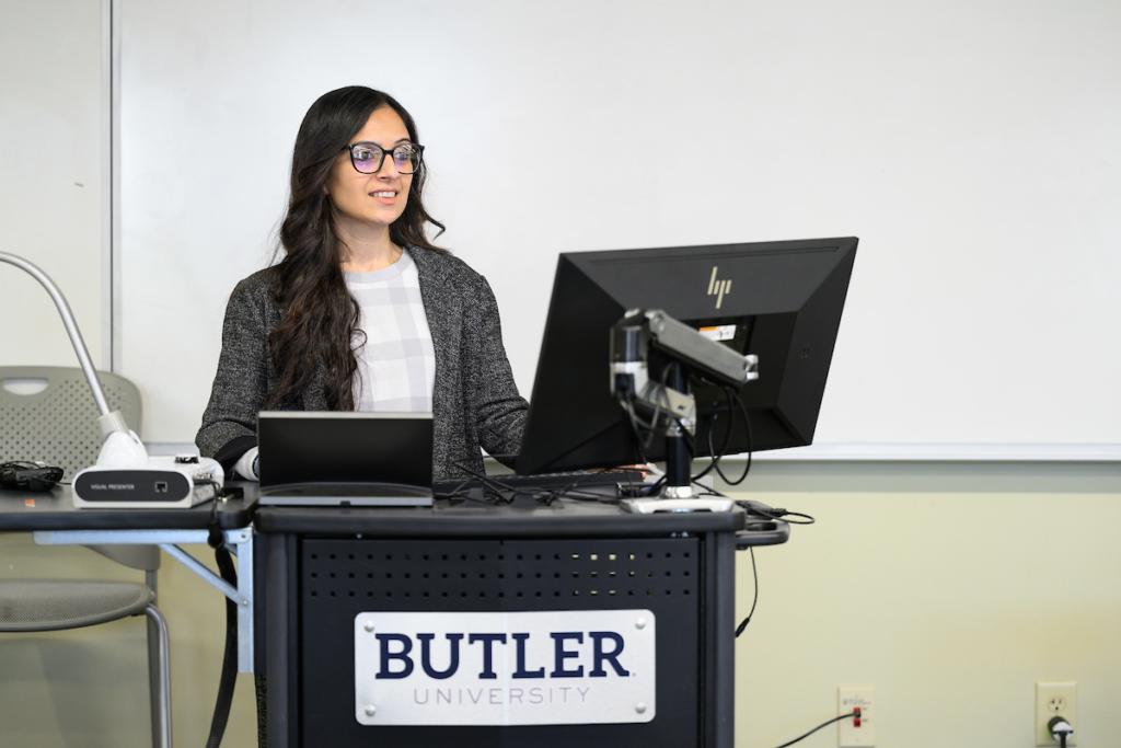 Woman at podium giving presentation through computer